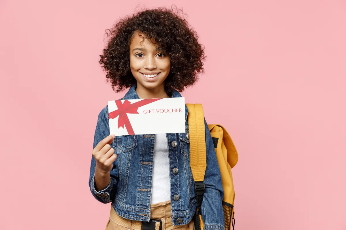 enfant tenant un chèque cadeau rentrée scolaire