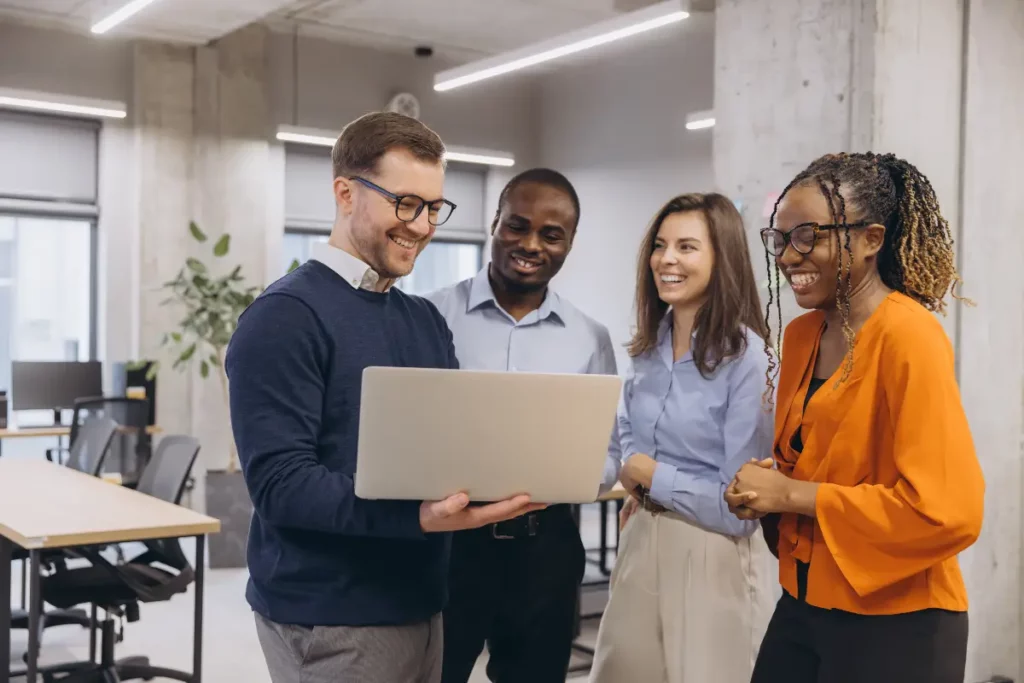 Groupe de professionnels engagés et heureux travaillant sur un ordinateur portable