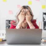 Femme d'affaires fatiguée se frotte les yeux dans son bureau